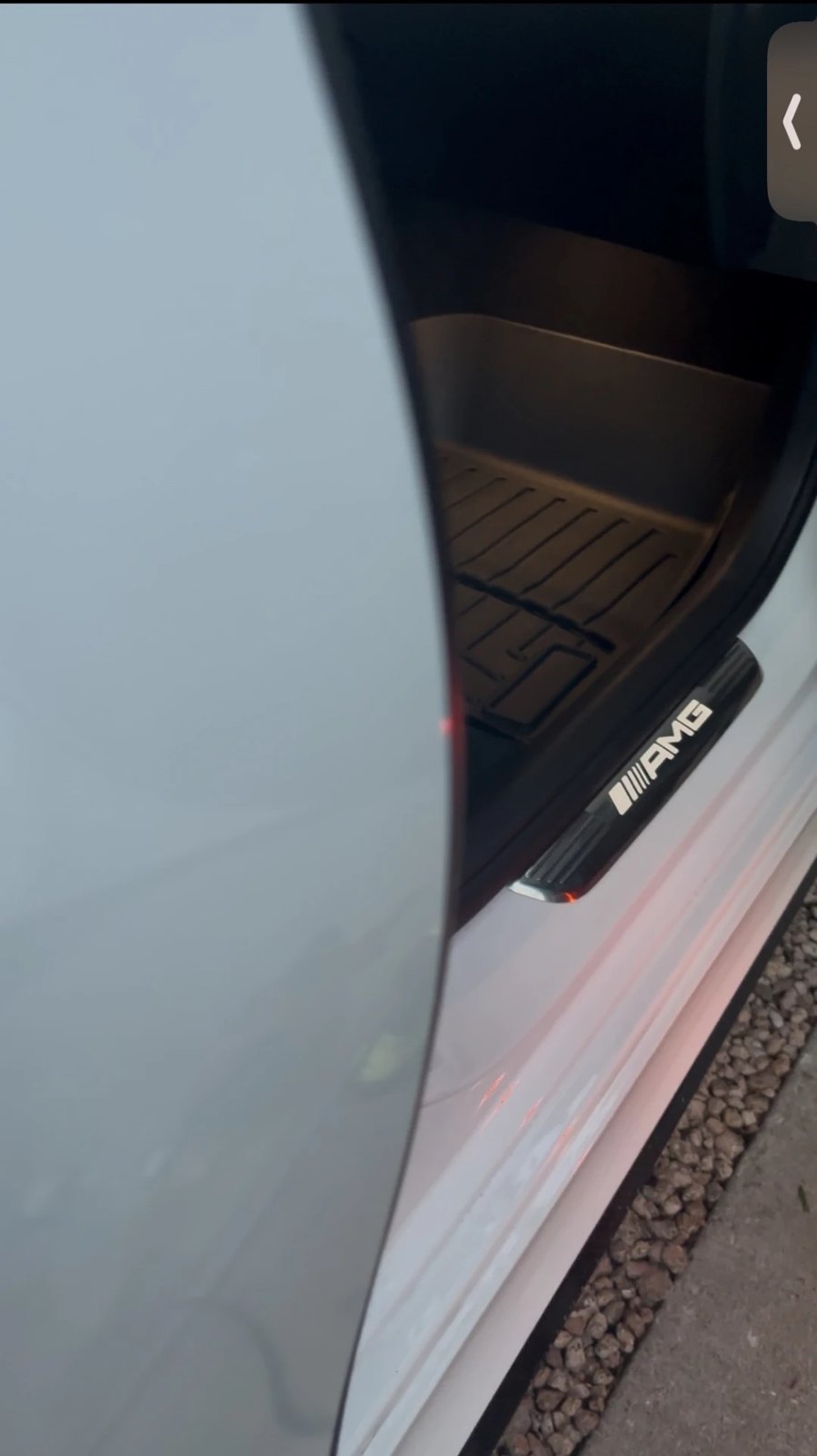 Illuminated AMG door sill and clean footwell of a white Mercedes-AMG after a detail