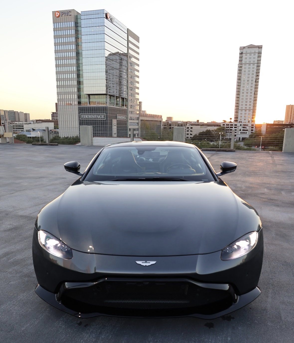 Black Aston Martin Vantage detailed to a deep gloss on a downtown Austin rooftop at sunset